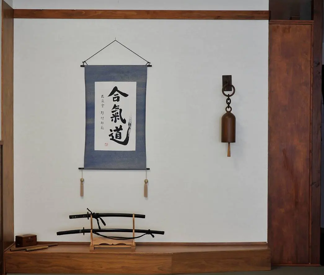 The dojo tokonoma with calligraphy, bell, and swords